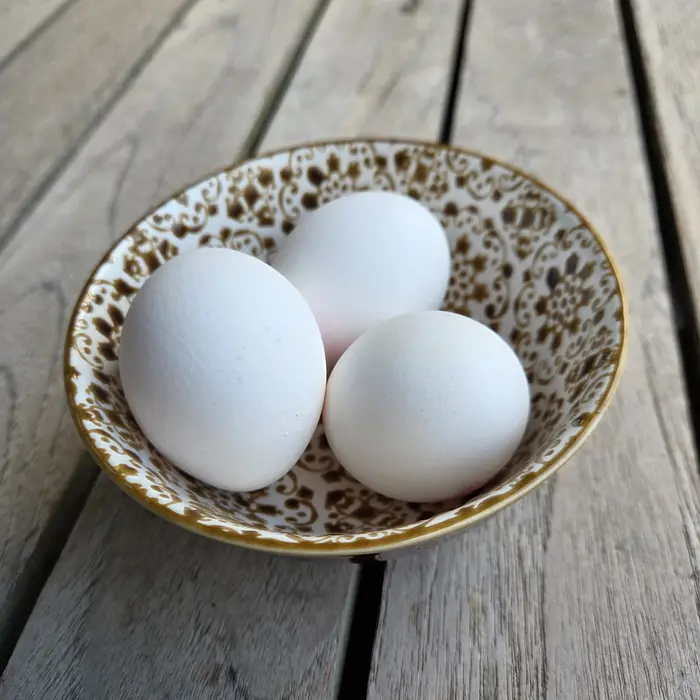 Fresh eggs in a bowl on a table