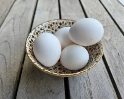 A bowl of fresh backyard eggs sitting on a table